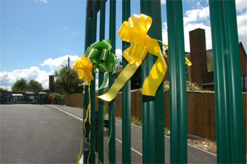 green metal gates decorated with yellow and green florist bows